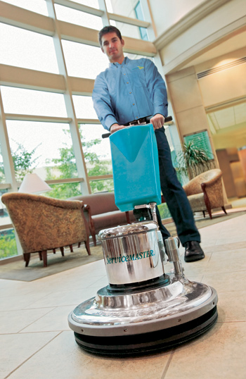 A ServiceMaster technician using specialty equipment to clean tile floors