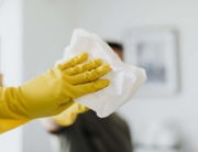 Unrecognizable man cleaning mirror in modern bathroom